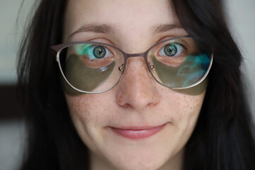 freckled girl in glasses with patches makes attempts at facial care