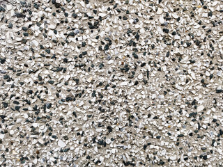 Wall surface of marble chips, black and white small stones in concrete. Wallpaper under a stone, background