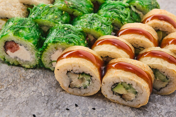 Japanese traditional cuisine: sushi. Assortment of sushi rolls on a gray background