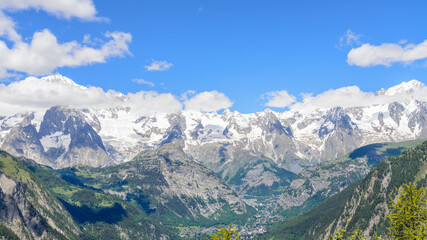 Fototapeta premium View of the highest mountain peaks in italy and in europe (White Mountain mountain range). Blue sky and white clouds on the background. Italian Alps