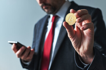 Businessman using mobile smart phone app for Bitcoin mining