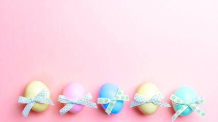 Fototapeta na wymiar Easter background pink. Colourful egg with tape ribbon on pastel pink background in Happy Easter decoration. Flat lay, top view.