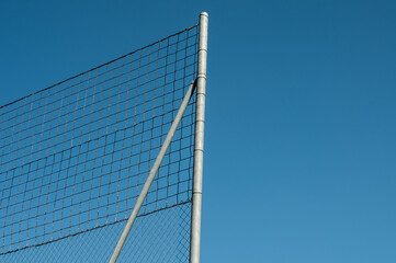 a high wire mesh fence at blue sky