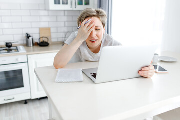 Obraz na płótnie Canvas tired woman in stress working on laptop