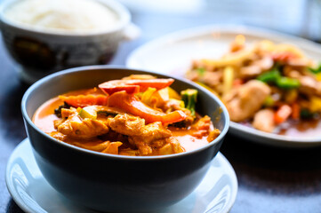 Thai food in a dark bowl with rice on the side