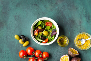 Salad maracuja tomatoes pepper on green background. Organic food.