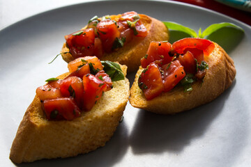 Italian bruschetta with roasted tomatoes, basil and garlic. Top view photo of savory toast. Healthy eating concept. 