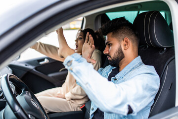 Young indian man and a woman in a stressful situation during car driving