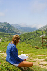 A girl is reading a book in the mountain