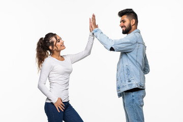 Portrait of an indian young couple giving high five over gray background
