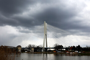Piękny linowy most drogowy nad rzeką w burzową pogodę.  - obrazy, fototapety, plakaty
