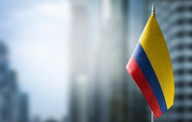 A small flag of Colombia on the background of a blurred background