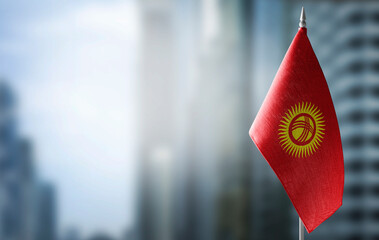 A small flag of Kirghizia on the background of a blurred background
