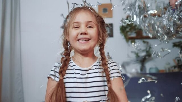 baby birthday. happy little girl throwing a up silver confetti. birthday kid dream concept. happy joyful girl on holiday throws up shiny confetti. child on holiday slow motion fun video
