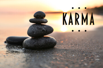 Karma concept. Stones on sand near sea at sunset - obrazy, fototapety, plakaty