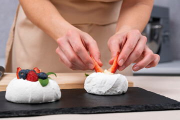 Obraz na płótnie Canvas Pastry chef prepares berry dessert. Strawberry cake decorating process