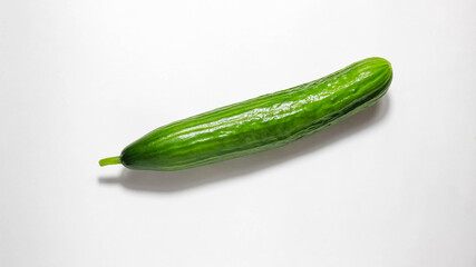 A whole fresh cucumber on a white background.