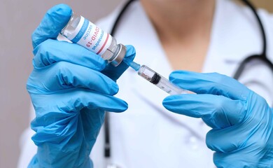 Doctor, nurse, scientist hand in blue gloves holding coronavirus, covid-19 vaccine and syring.