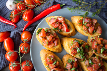 Italian bruschetta with roasted tomatoes, basil and garlic. Top view photo of savory toast. Healthy eating concept. 