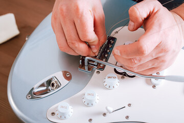 Guitar master making professional guitar maintenance, hands with tools close up. Guitar technician...