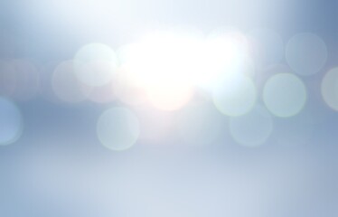 Bokeh flares on cool light blue backgrond for winter holidays decor.