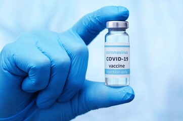 Doctor or laborant in protective gloves holding ampule tube with nCoV Coronavirus vaccine for COVID virus.