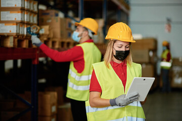 Caucasian female worker checking the order inside a warehouse while wearing a face mask - Face focus