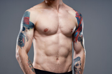 sporty man with pumped up abs cropped view of tattoo on arms close-up