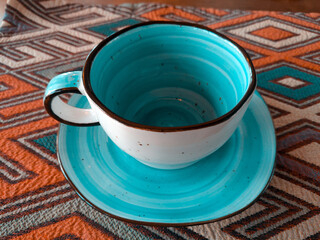 turquoise ceramic mug with a plate stand in a cafe on the table