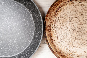 Comparison of pans. Old and new frying pan. New and old damaged non-stick coating.
