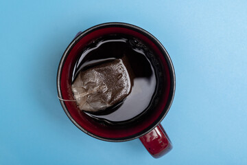 Tea bag in a cup on a blue background.