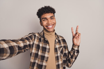 Photo of guy take selfie show v-sign toothy smile wear checkered shirt turtleneck isolated grey color background
