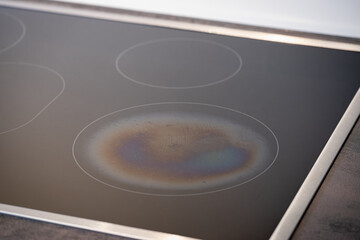 Iridescent Burnt Metal Traces in a Ceramic Glass Induction Stove