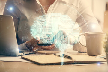 Double exposure of brain sketch hologram and woman holding and using a mobile device.