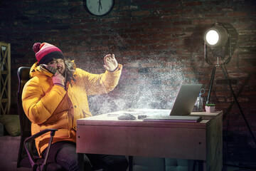 Young man in bright yellow puffy jacket meeting winter on virtual video call.