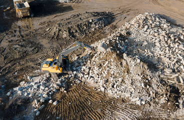 Recycling concrete and construction waste from demolition. Excavator at landfill of the disposa....
