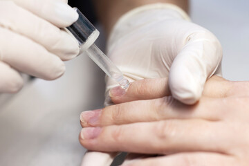 Manicure hand nail care with a special device in a beauty salon by a manicure specialist. Close-up. Space for the text.