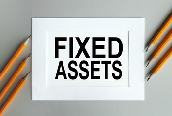 fixed assets. text on white paper in a white frame. on gray background