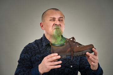 Man holding a stinking shoe