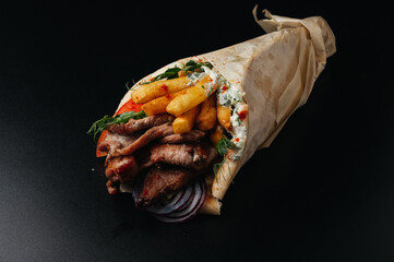 Greek gyros wrapped in pita breads on black background. Gyro pita, shawarma, take away, street food