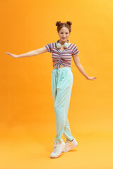 Excited  lady dancing on yellow background.