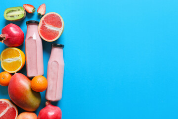 Bottles of tasty smoothie with fruits on color background