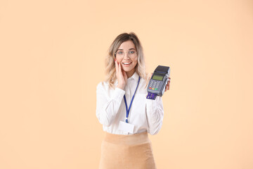 Young woman with payment terminal on color background
