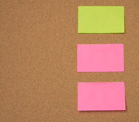 multicolored paper sticks are glued to the brown cork board