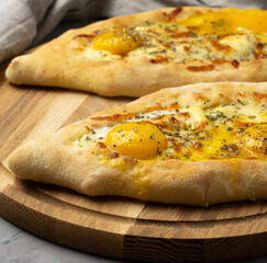 baked adjarian khachapuri on wooden board, traditional dish