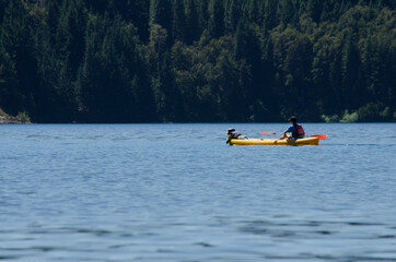 kayaking, two people paddling on lake with mountain