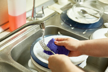 housewife washing dishes in the kitchen, selective focus