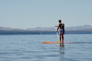 Stand Up Paddle Surfing, young man on board in lake