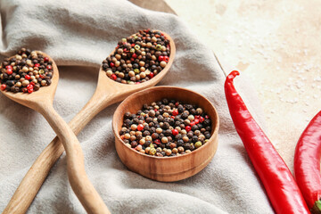 Mixed peppercorns and chili peppers on light background