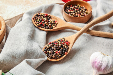Bowl and spoons with mixed peppercorns on table